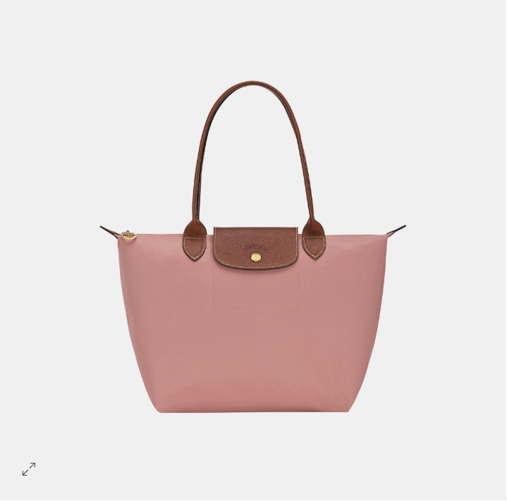 Pink tote handbag with brown handles and trim on a light gray background