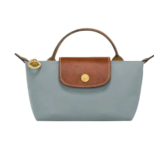 A light blue leather handbag with a brown textured flap and gold-tone hardware, shown against a plain white background.