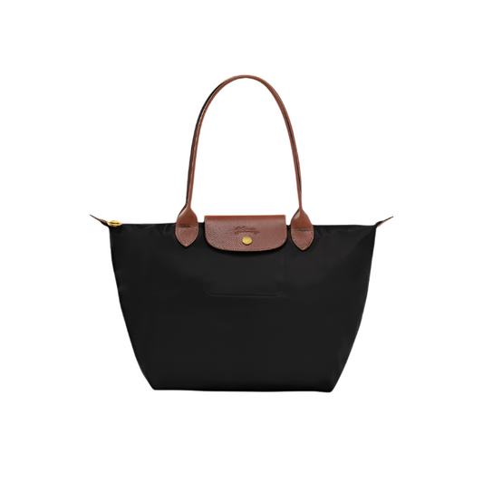 Black tote bag with brown leather handle and trim on a white background- black purse
