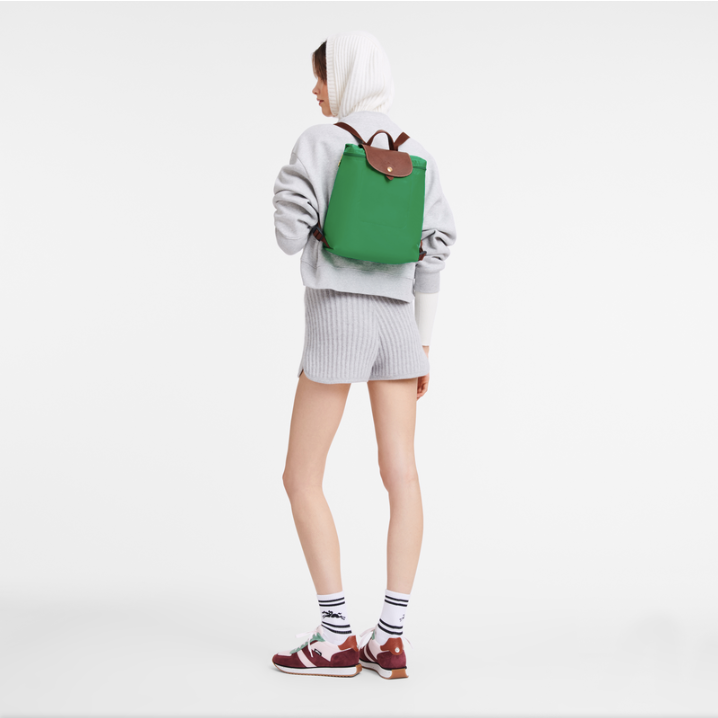 Person wearing a green the backpack on a white background