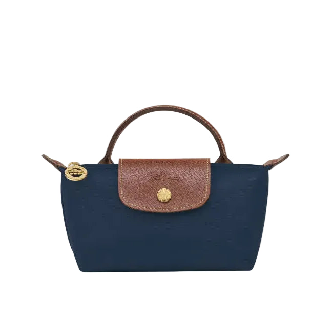 A navy blue fold-over handbag with brown leather trim, a top handle, and gold-tone hardware, shown on a plain light gray background.